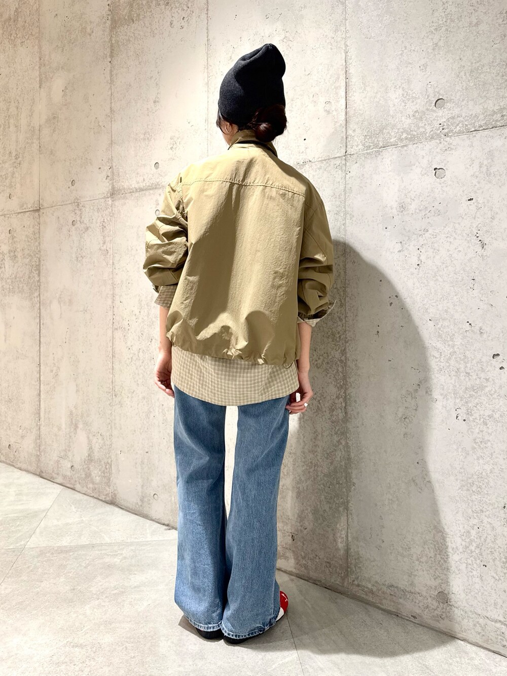 ベージュ系のナイロンジャケット、ブラウン系のスニーカー、ブラック系のショルダーバッグを着用したレディースの春コーディネートの7枚目の写真