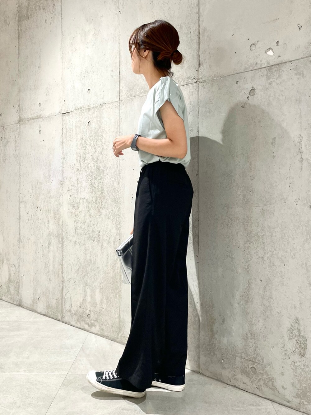 シルバー系のクラッチバッグ、グリーン系のTシャツ/カットソー、ブラック系のその他パンツを着用したレディースの夏コーディネートの3枚目の写真