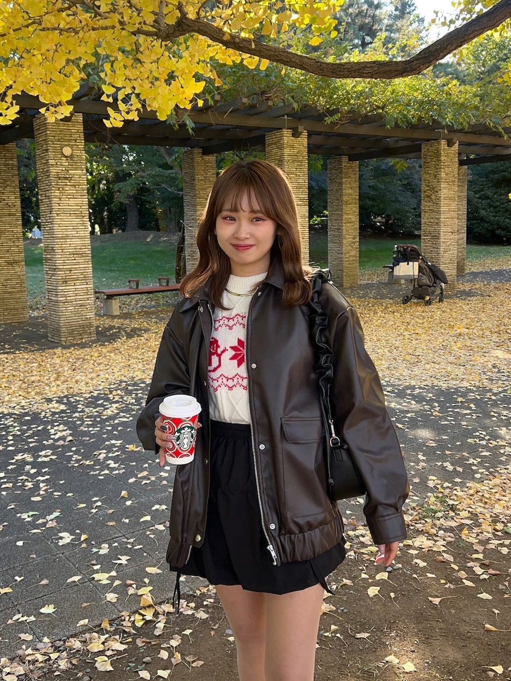 ブラウン系のブルゾン、ベージュ系のブーツ、ホワイト系のニット/セーターを着用したレディースの秋コーディネートの3枚目の写真