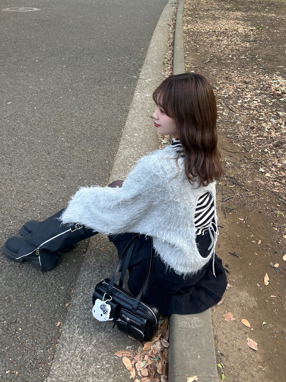 グレー系のニット/セーター、ブラック系のニット/セーター、ブラック系のブーツを着用したレディースの冬コーディネートの2枚目の写真