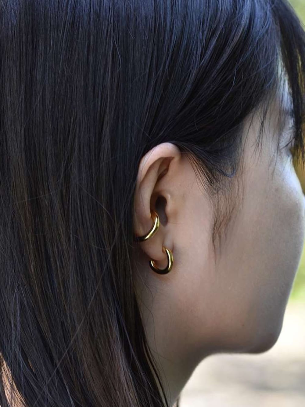 ブラック系のスカート、ホワイト系のローファー、ブラック系のニット/セーターを着用したレディースの夏コーディネートの2枚目の写真