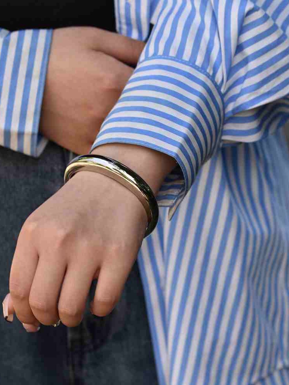 ブルー系のデニムパンツ、ブルー系のシャツ/ブラウス、シルバー系のバングル/リストバンドを着用したレディースの夏コーディネートの4枚目の写真