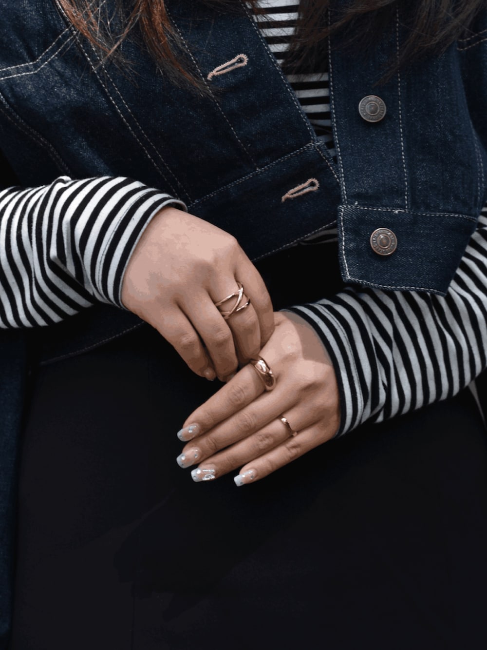 ブラック系のスカート、ブルー系のデニムジャケット、ホワイト系のスニーカーを着用したレディースの春コーディネートの3枚目の写真