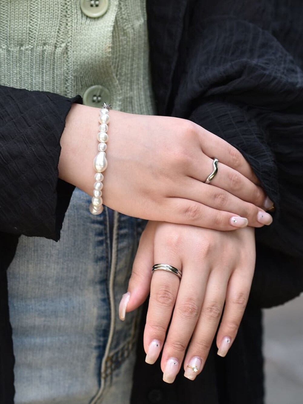 ブルー系のデニムパンツ、シルバー系のネックレス、シルバー系のリングを着用したレディースの春コーディネートの3枚目の写真