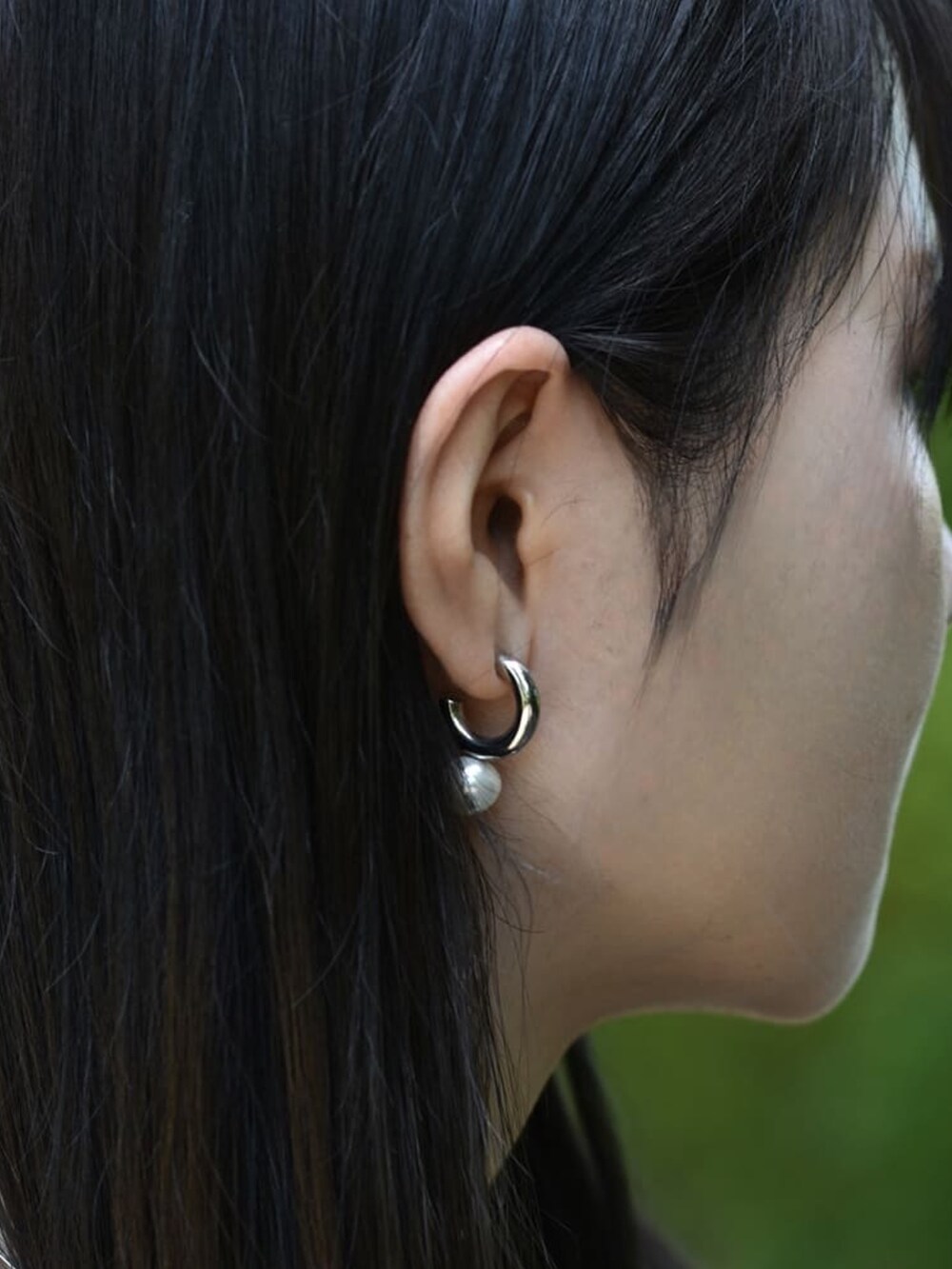 ブルー系のデニムパンツ、シルバー系のネックレス、シルバー系のリングを着用したレディースの春コーディネートの4枚目の写真