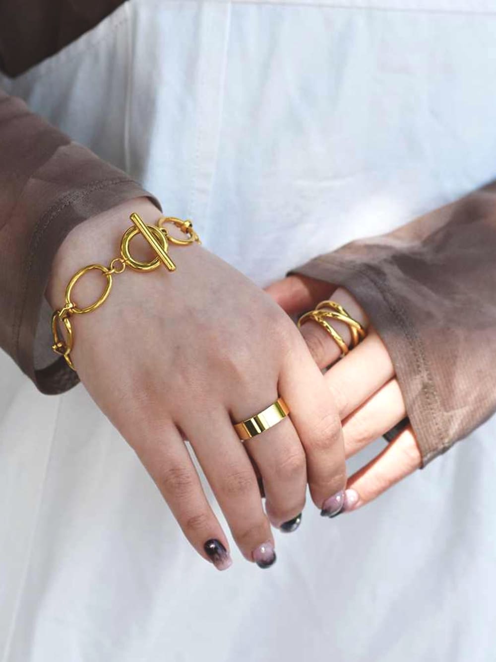 ホワイト系のワンピース、ブラウン系のTシャツ/カットソー、ゴールド系のネックレスを着用したレディースの春コーディネートの3枚目の写真