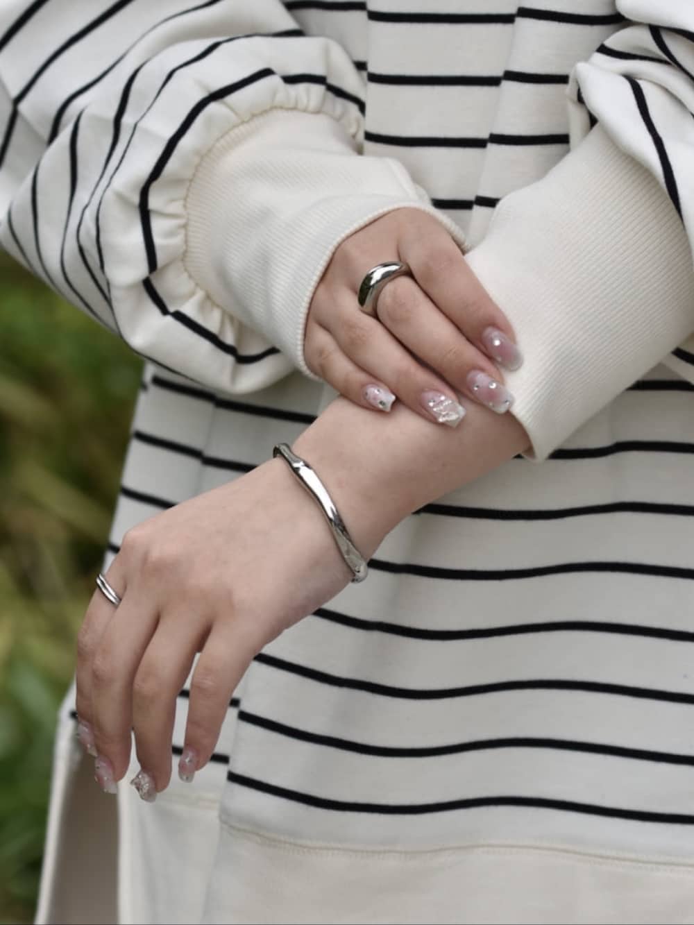 ブラック系のその他パンツ、ホワイト系のスウェット、シルバー系のネックレスを着用したレディースの春コーディネートの3枚目の写真