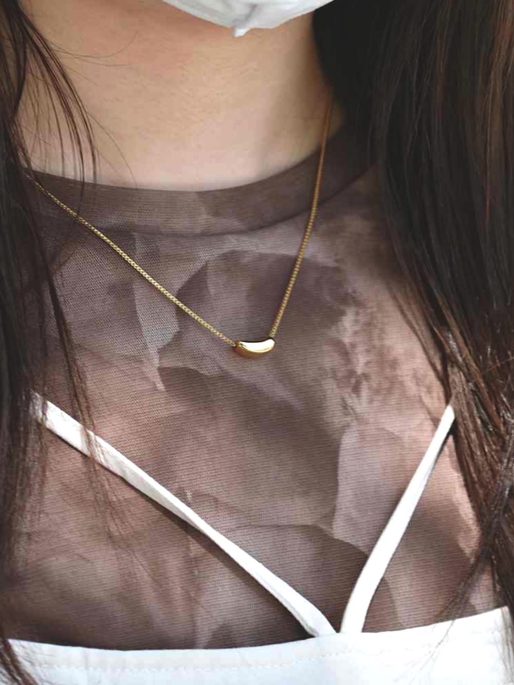 ホワイト系のワンピース、ブラウン系のTシャツ/カットソー、ゴールド系のネックレスを着用したレディースの春コーディネートの2枚目の写真