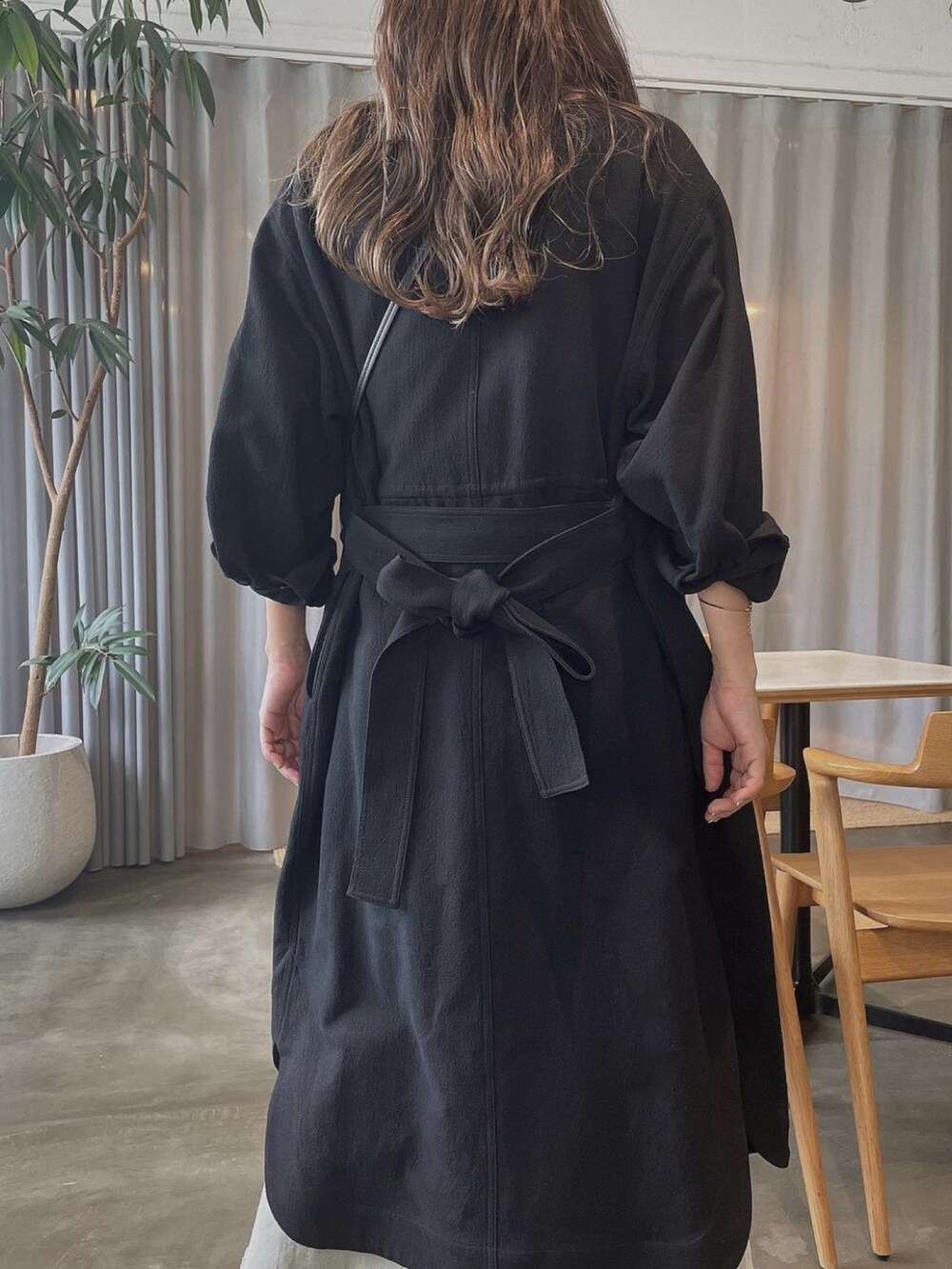 ベージュ系のスカート、ブラック系のノーカラーコート、ホワイト系のTシャツ/カットソーを着用したレディースの秋コーディネートの3枚目の写真