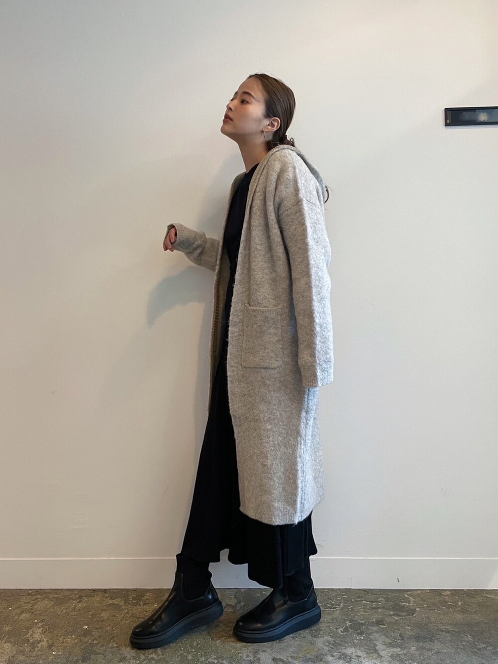 ベージュ系のカーディガン/ボレロ、ブラック系のワンピースを着用したレディースの冬コーディネートの2枚目の写真