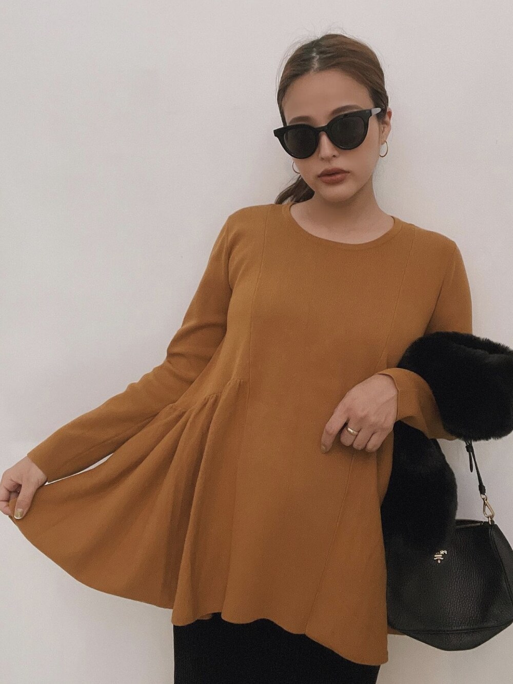 ブラウン系のニット/セーター、ブラック系のネックウォーマー/スヌードを着用したレディースの冬コーディネートの3枚目の写真