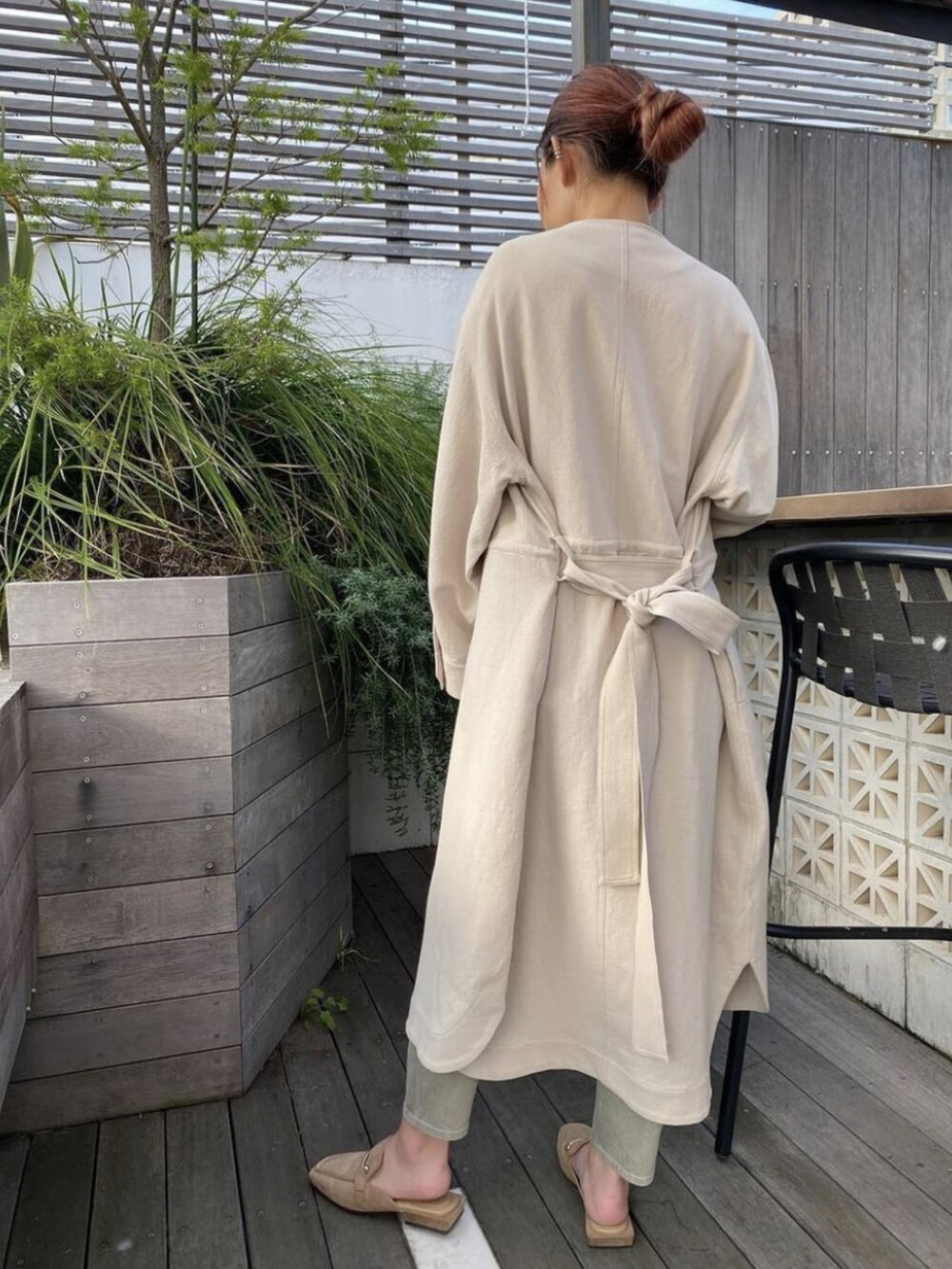 ベージュ系のノーカラーコート、ベージュ系のローファー、グレー系のその他パンツを着用したレディースの冬コーディネートの2枚目の写真