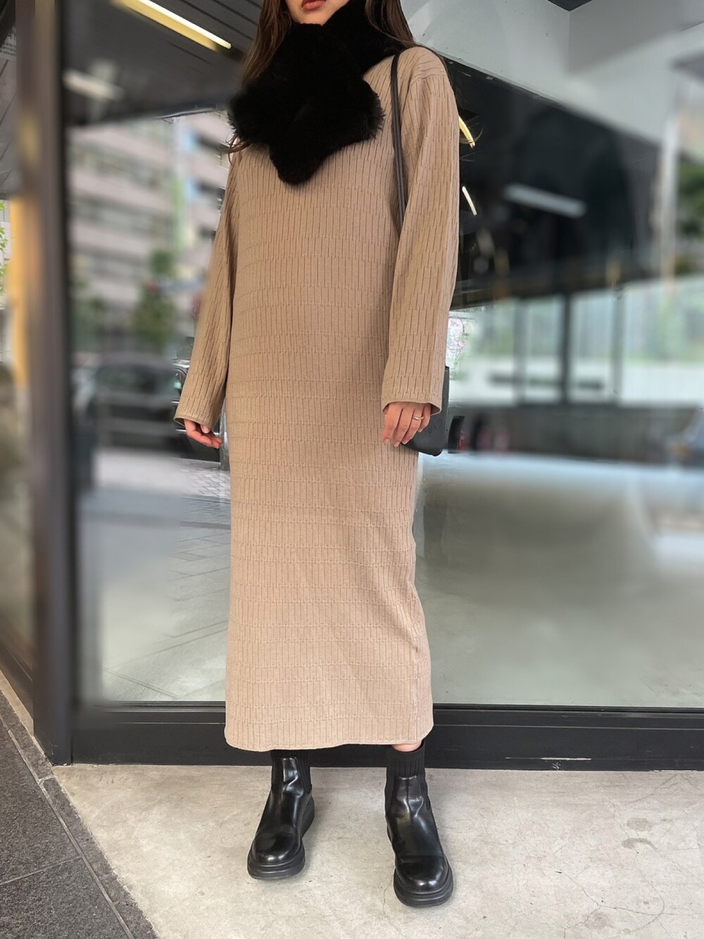 ベージュ系のワンピース、ブラック系のネックウォーマー/スヌードを着用したレディースの冬コーディネートの2枚目の写真