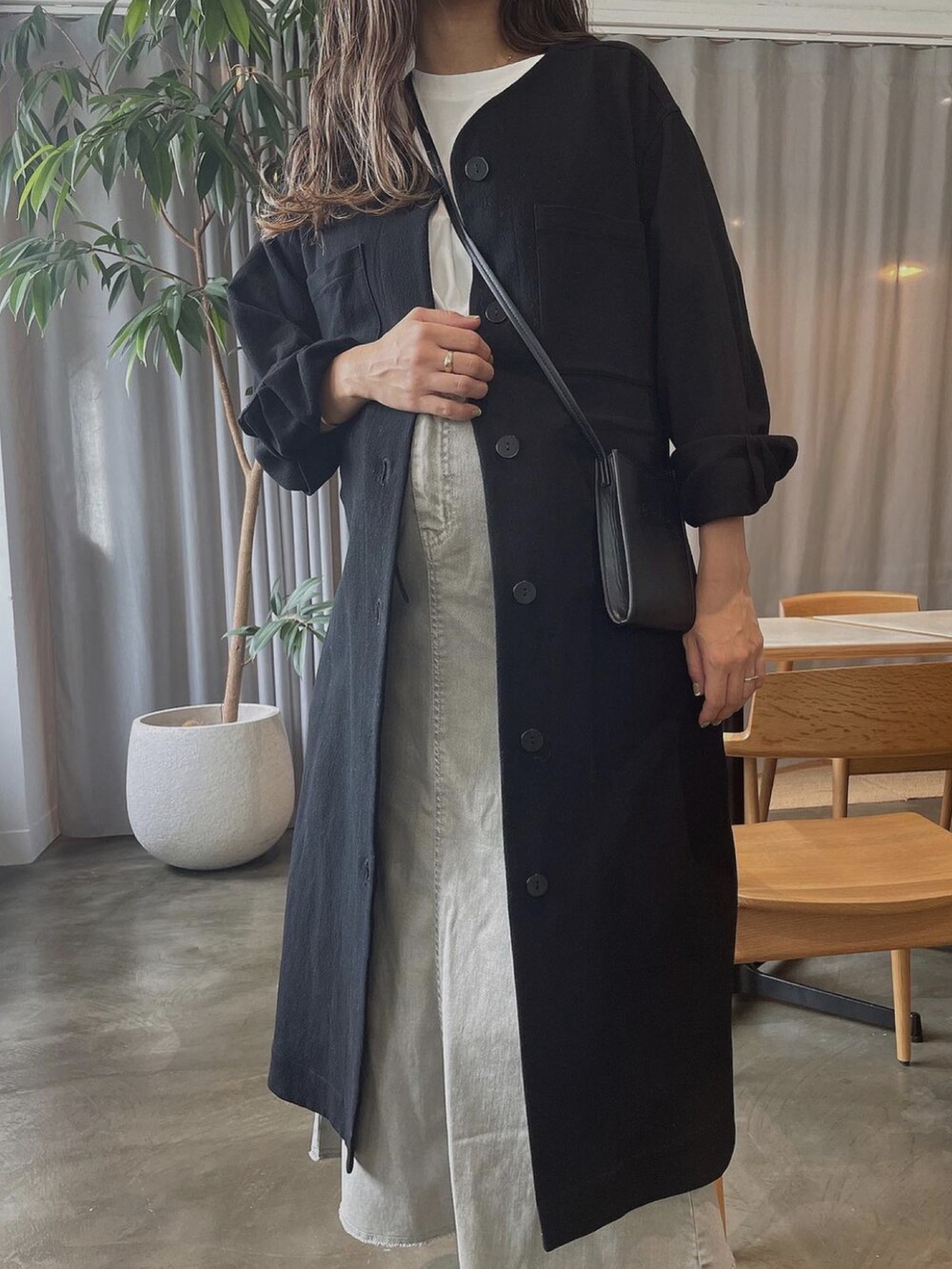 ベージュ系のスカート、ブラック系のノーカラーコート、ホワイト系のTシャツ/カットソーを着用したレディースの秋コーディネートの2枚目の写真