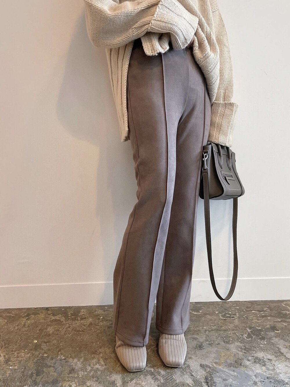 ベージュ系のその他パンツ、ベージュ系のブーツ、ホワイト系のニット/セーターを着用したレディースの冬コーディネートの2枚目の写真