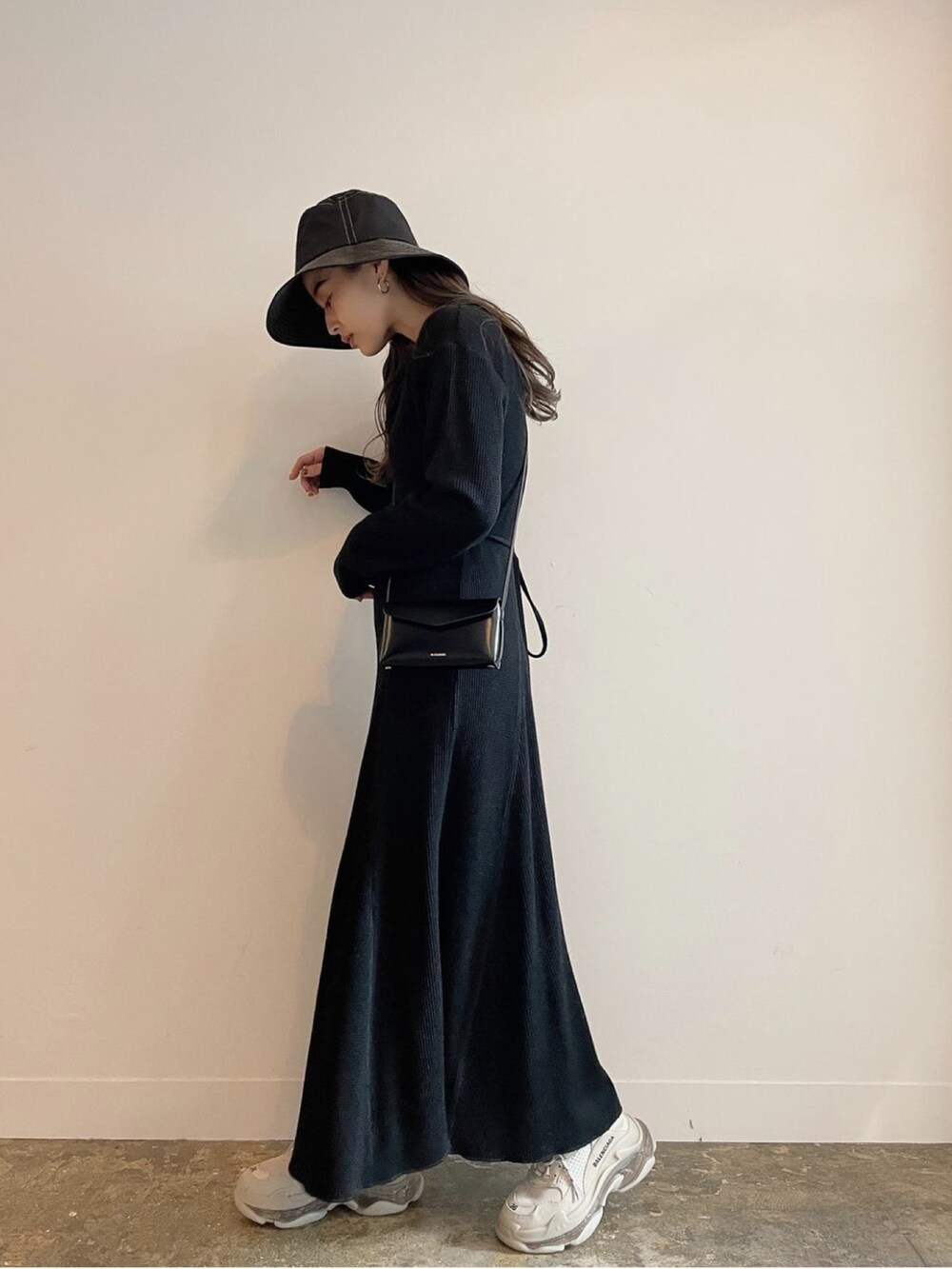 ブラック系のワンピース、ブラック系のハットを着用したレディースの春コーディネートの2枚目の写真