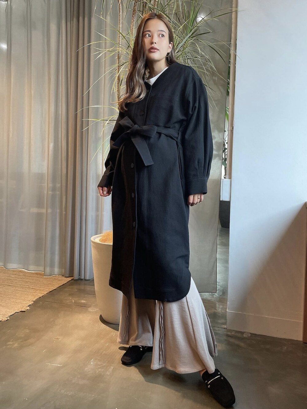 ブラック系のノーカラーコート、ブラック系のローファー、ホワイト系のTシャツ/カットソーを着用したレディースの冬コーディネートの2枚目の写真