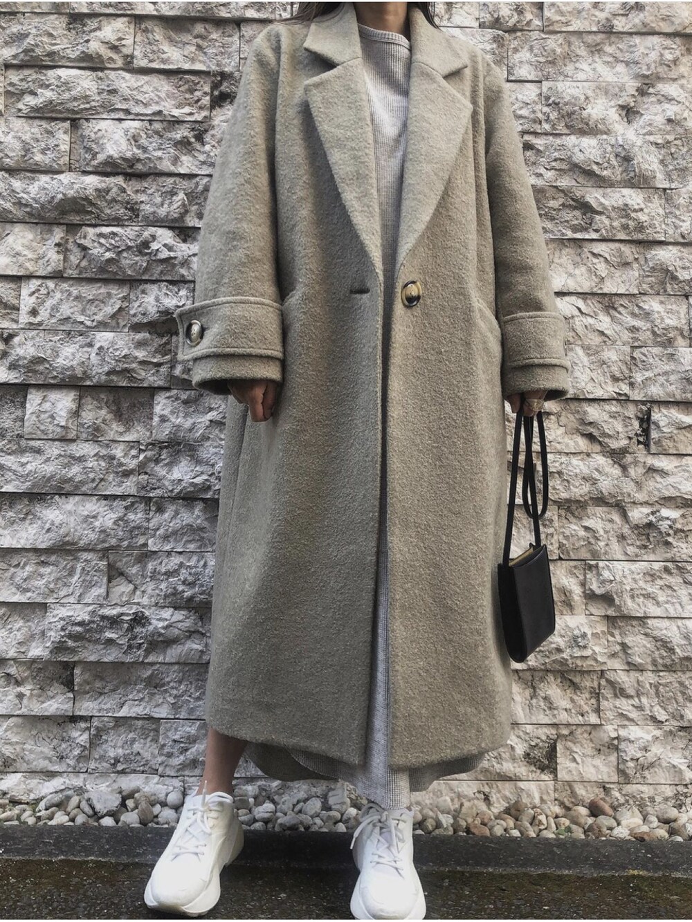 グリーン系のチェスターコートを着用したレディースの冬コーディネートの2枚目の写真