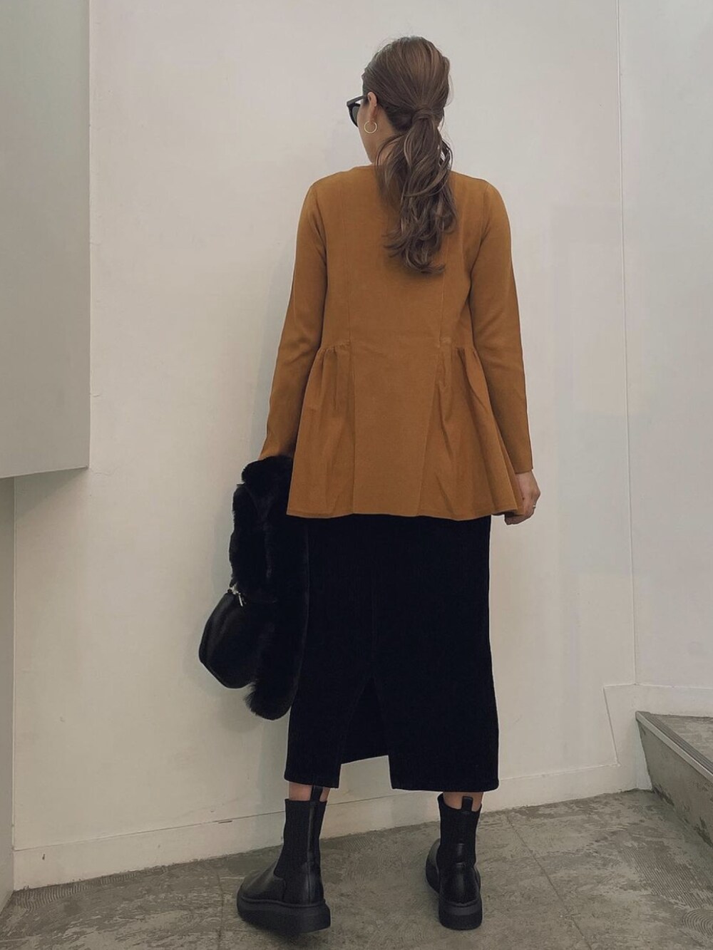 ブラウン系のニット/セーター、ブラック系のネックウォーマー/スヌードを着用したレディースの冬コーディネートの2枚目の写真