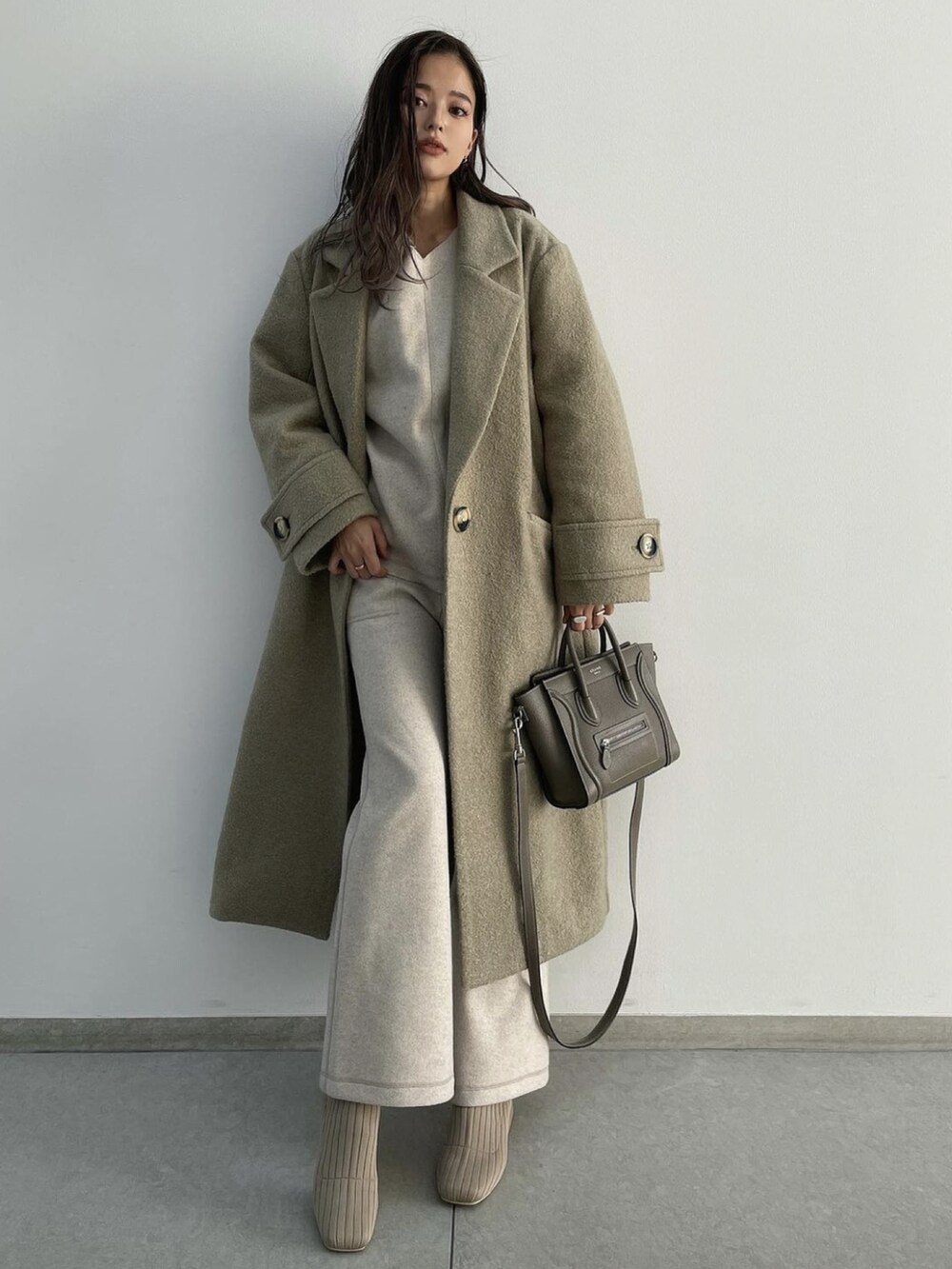 ベージュ系のブーツ、グリーン系のチェスターコート、ホワイト系のその他トップスを着用したレディースの冬コーディネートの2枚目の写真