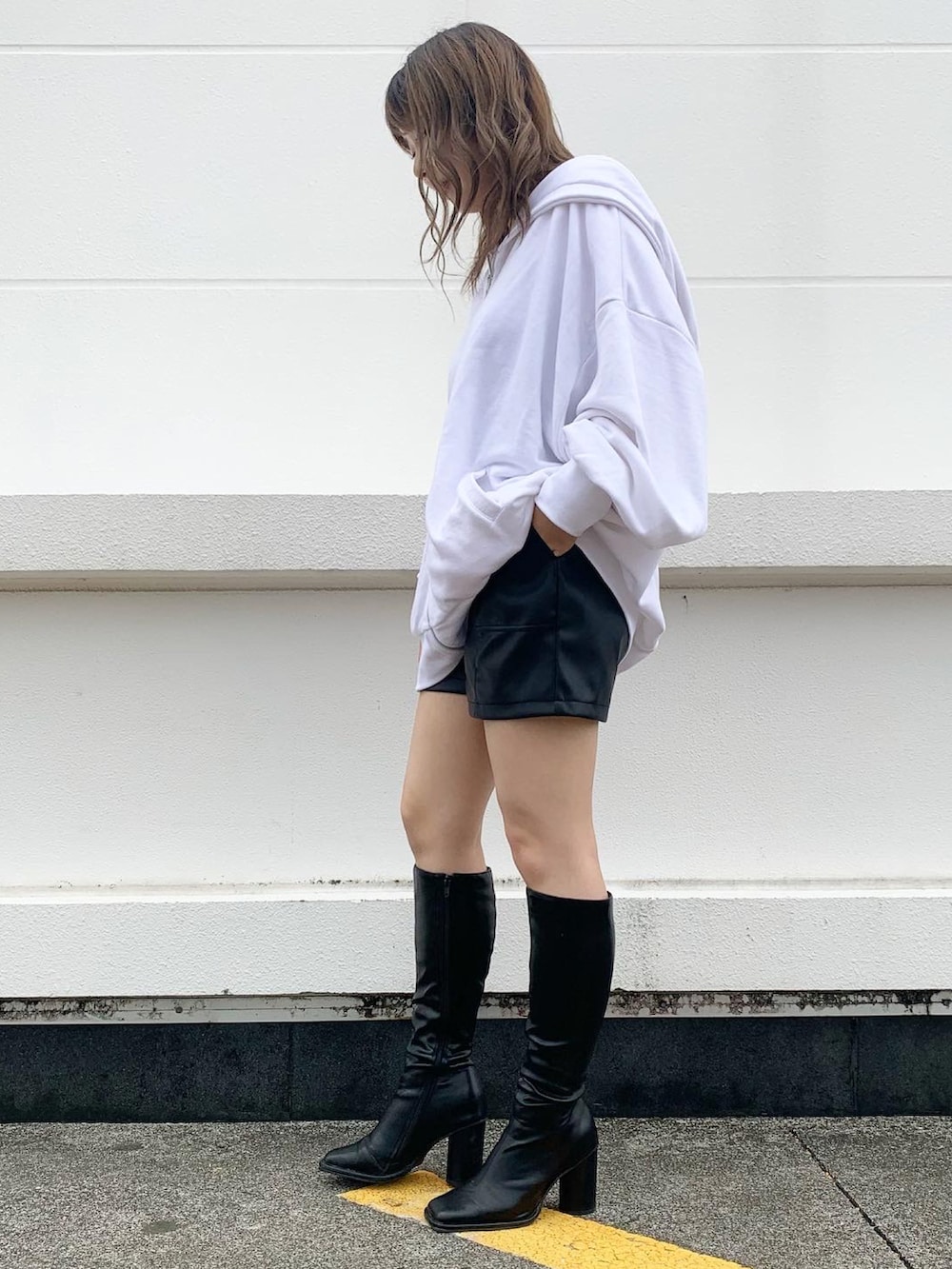 ブラック系のブーツ、ホワイト系のパーカー、ブラック系のその他パンツを着用したレディースの秋コーディネートの2枚目の写真