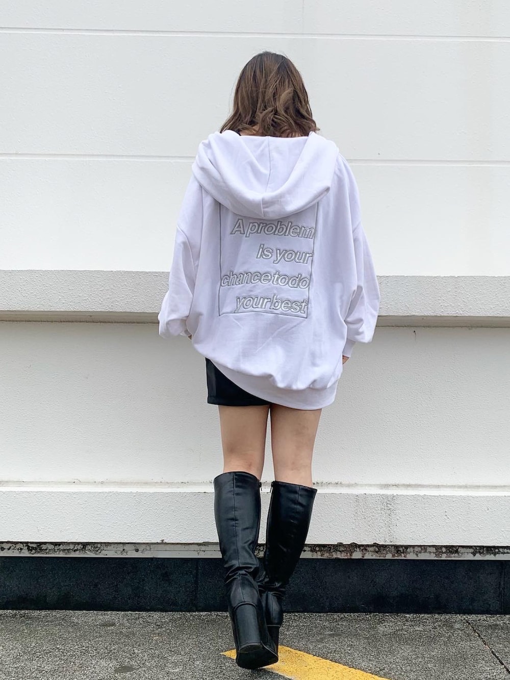 ブラック系のブーツ、ホワイト系のパーカー、ブラック系のその他パンツを着用したレディースの秋コーディネートの3枚目の写真