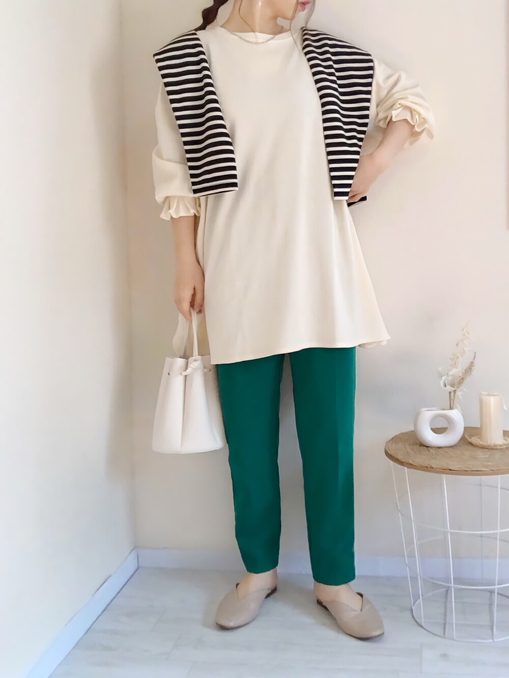 ホワイト系のTシャツ/カットソー、ブラック系のカーディガン/ボレロ、グリーン系のパンツを着用したレディースの春コーディネートの2枚目の写真