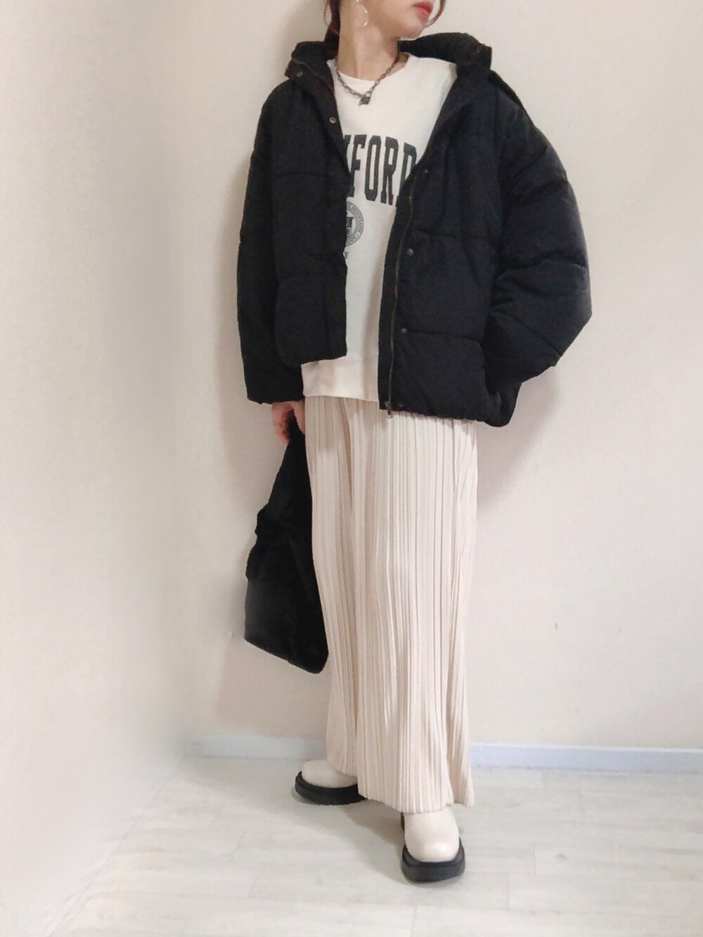 ブラック系のダウンジャケット/コート、ホワイト系のスウェット、ホワイト系のその他パンツを着用したレディースの冬コーディネートの2枚目の写真