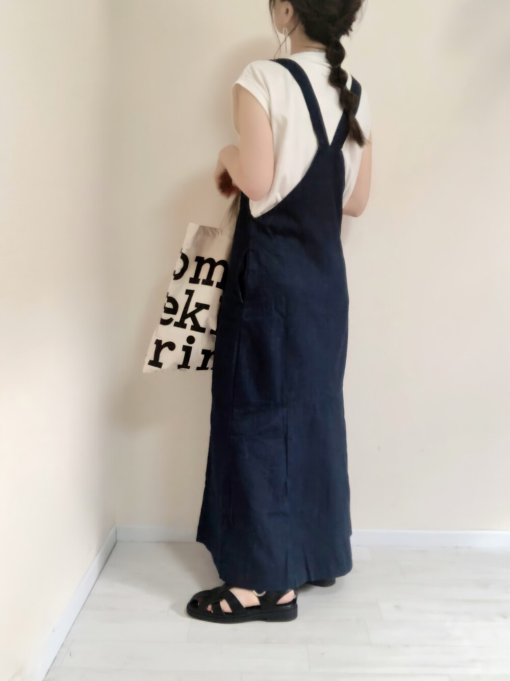 ブルー系のジャンパースカート、ホワイト系のTシャツ/カットソー、ホワイト系のトートバッグを着用したレディースの夏コーディネートの2枚目の写真