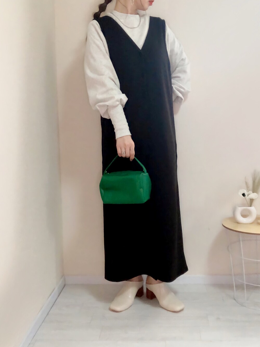 ベージュ系のスウェット、ブラック系のジャンパースカート、ホワイト系のその他シューズを着用したレディースの春コーディネートの2枚目の写真