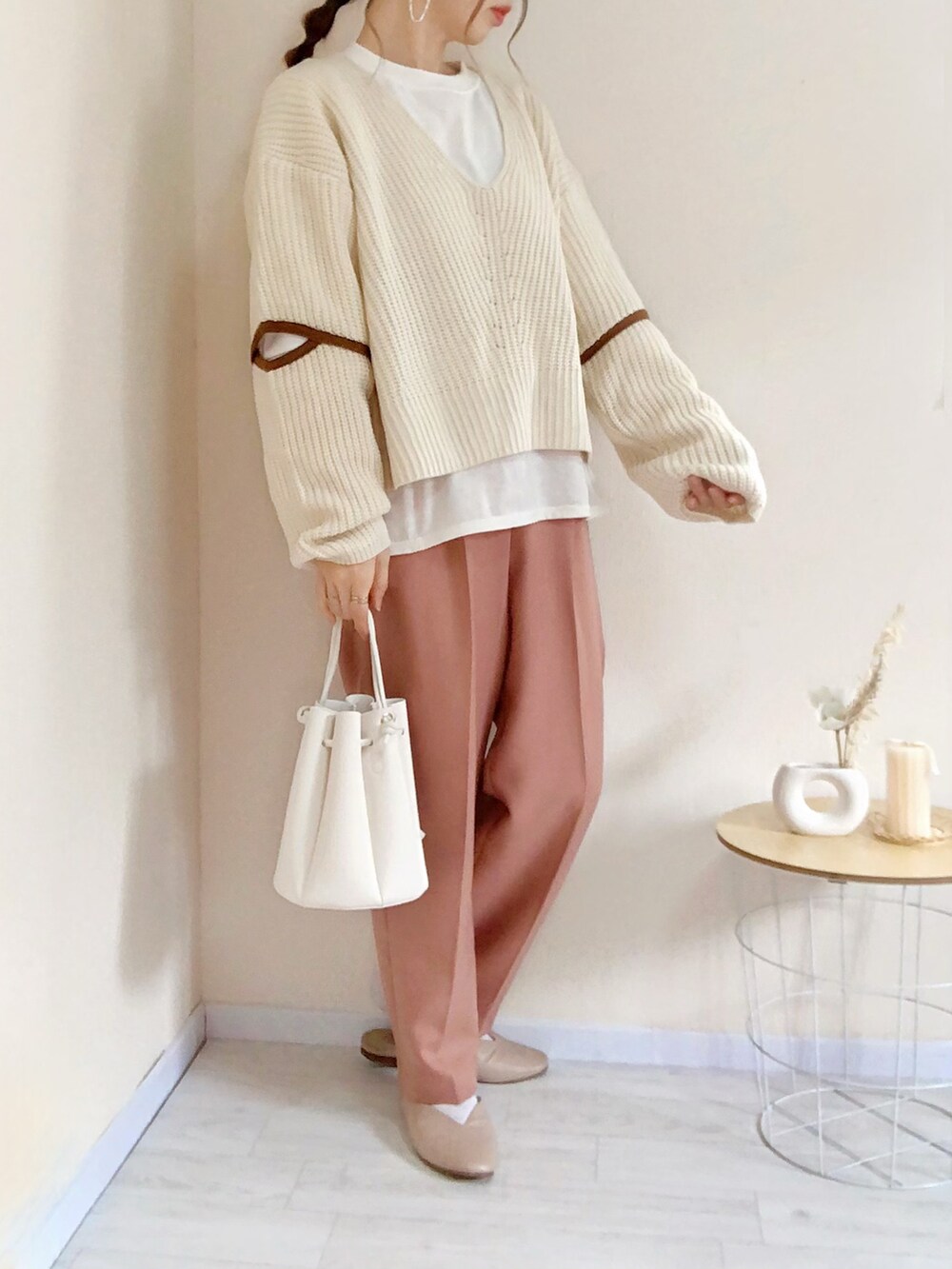 ホワイト系のニット/セーター、ブラウン系のその他パンツ、ホワイト系のショルダーバッグを着用したレディースの春コーディネートの2枚目の写真