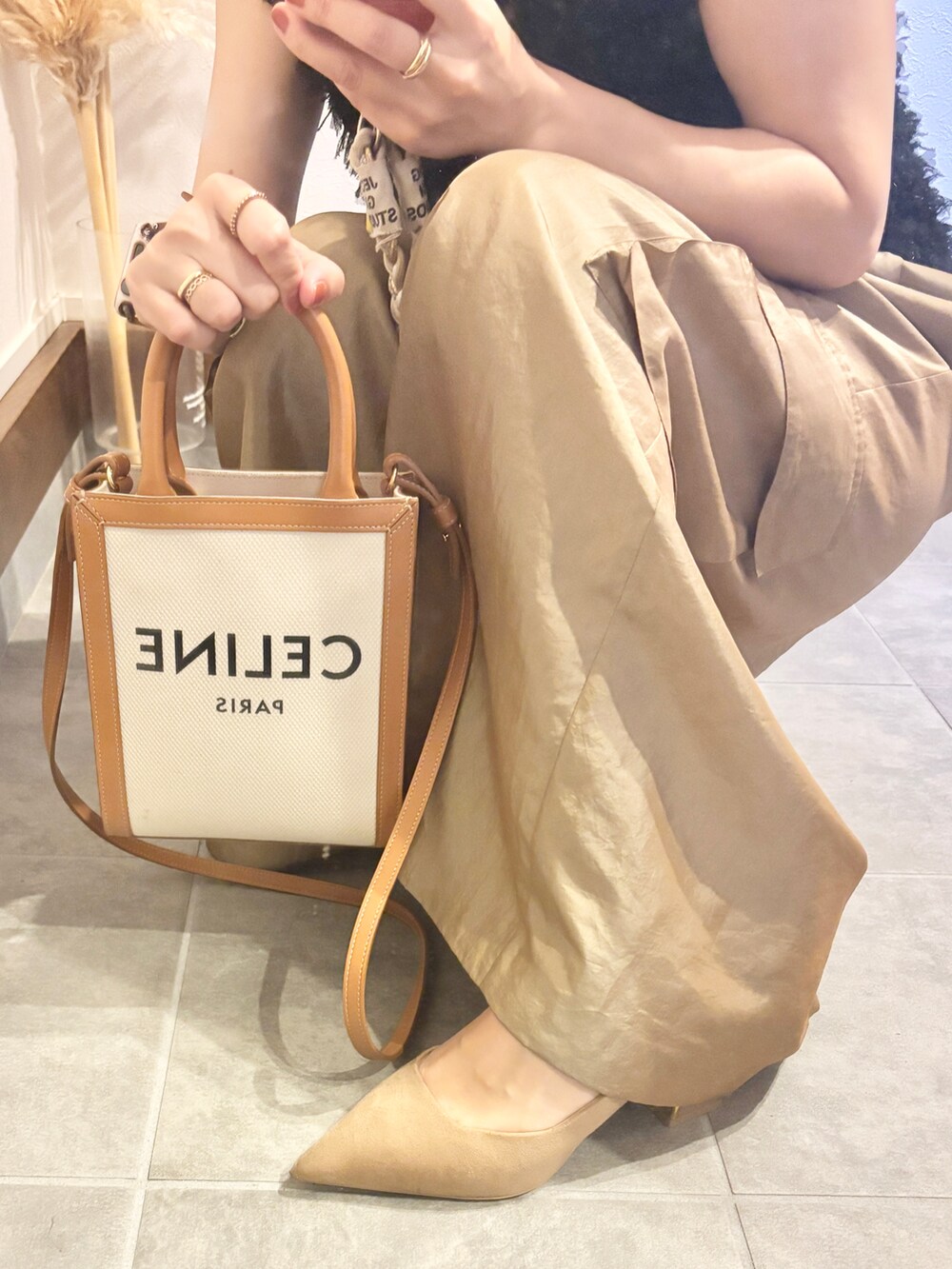 ブラック系のベスト、ゴールド系のカーゴパンツ、ゴールド系のパンプスを着用したレディースの秋コーディネートの4枚目の写真