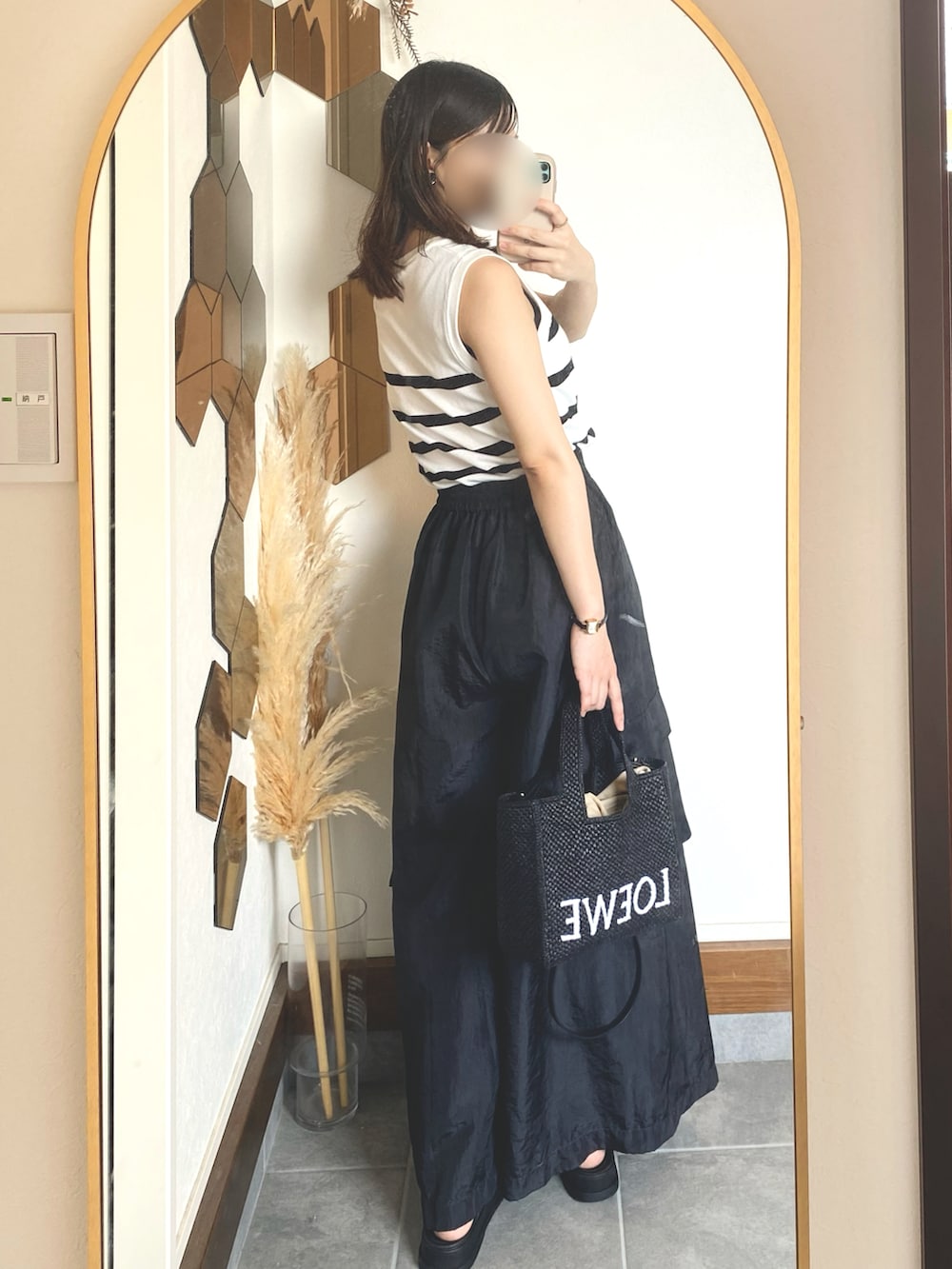 ブラック系のサンダル、ブラック系のトートバッグ、ブラック系のカーゴパンツを着用したレディースの夏コーディネートの2枚目の写真