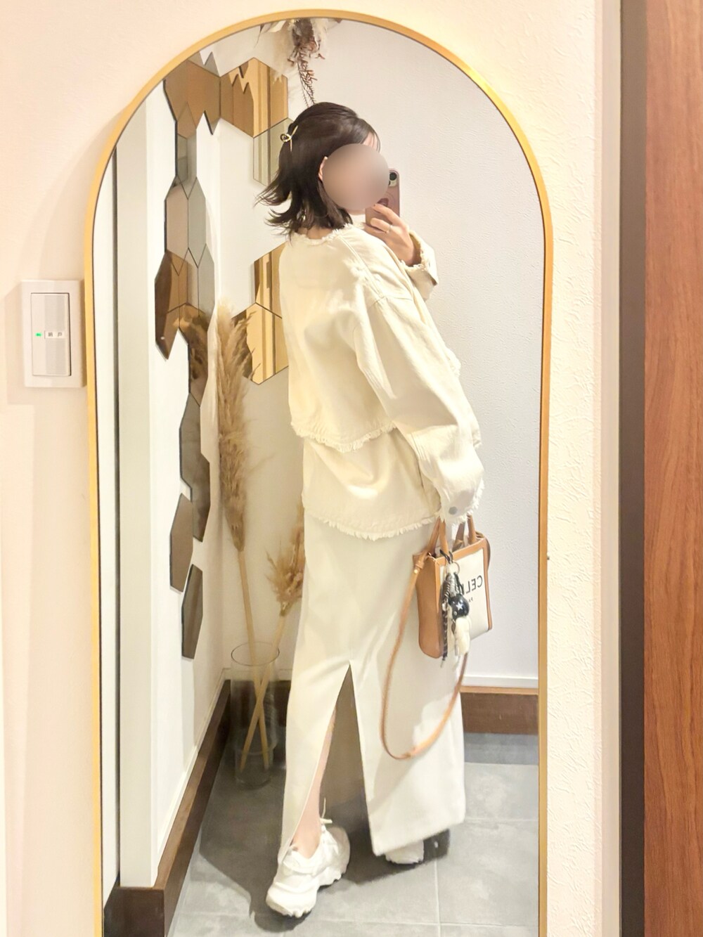 ホワイト系のスカート、グレー系のニット/セーター、ホワイト系のスニーカーを着用したレディースの秋コーディネートの2枚目の写真