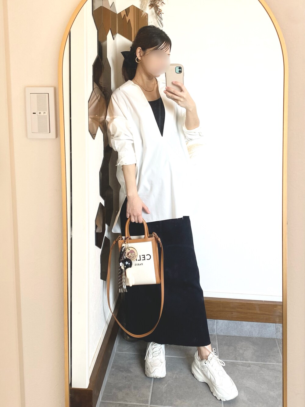 ホワイト系のシャツ/ブラウス、ブラック系のスカート、ホワイト系のスニーカーを着用したレディースの春コーディネートの2枚目の写真