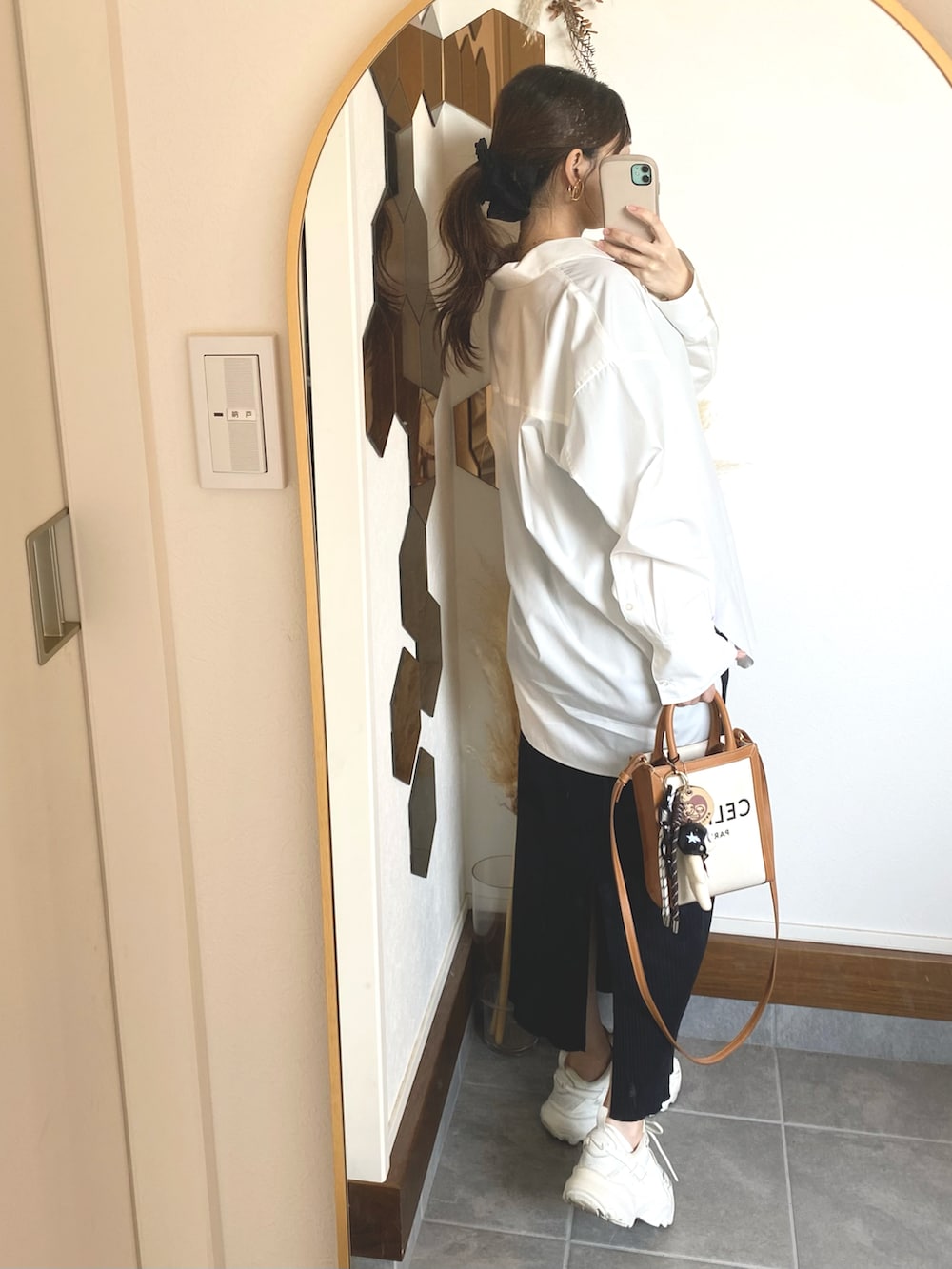 ホワイト系のシャツ/ブラウス、ブラック系のスカート、ホワイト系のスニーカーを着用したレディースの春コーディネートの3枚目の写真