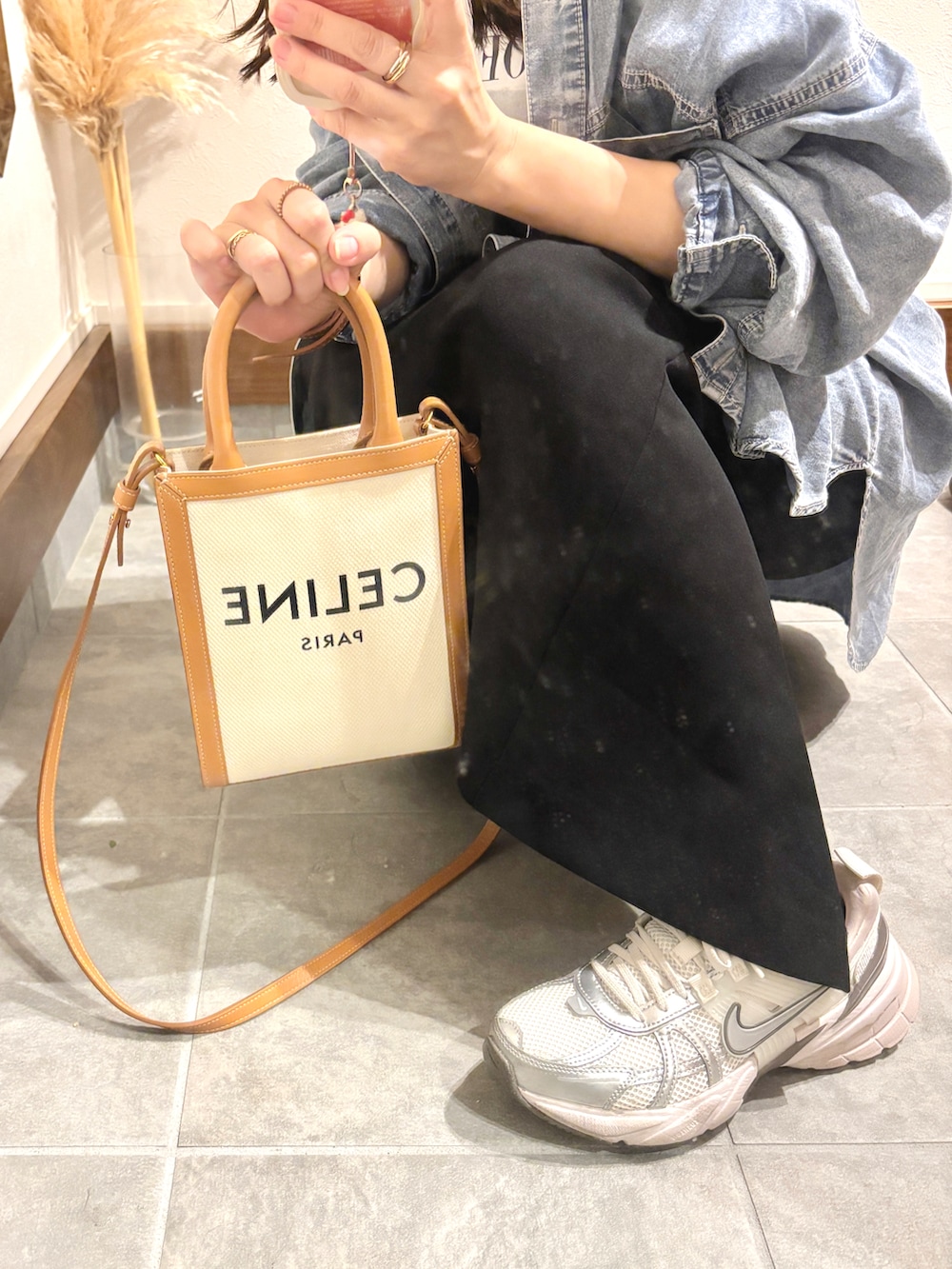 ブルー系のシャツ/ブラウス、ホワイト系のTシャツ/カットソー、ブラック系のスカートを着用したレディースの秋コーディネートの4枚目の写真
