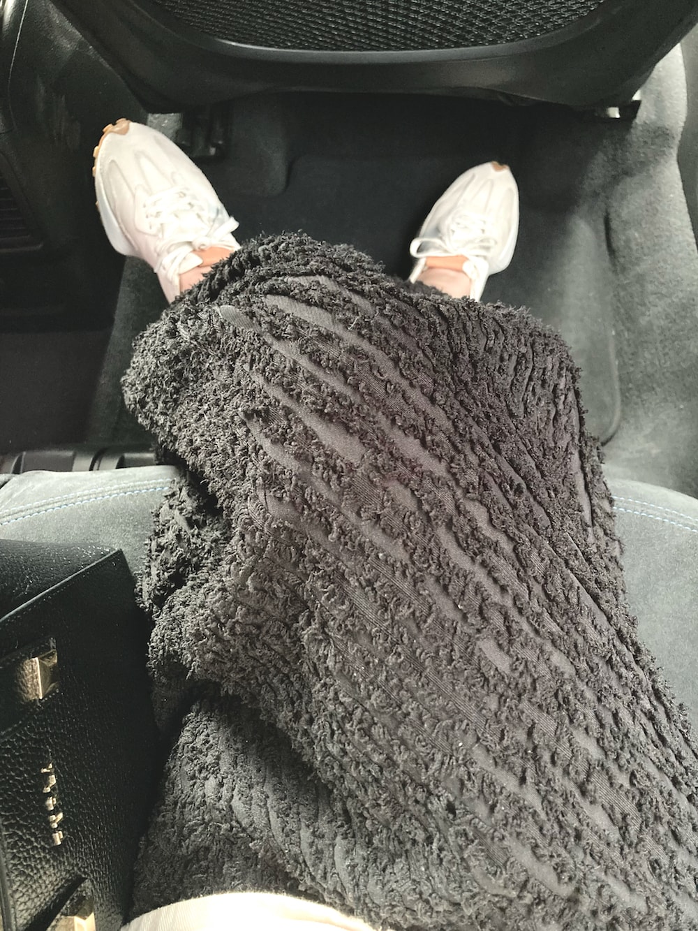 ブラック系のトートバッグ、ブラック系のスカート、ベージュ系のスニーカーを着用したレディースの秋コーディネートの2枚目の写真