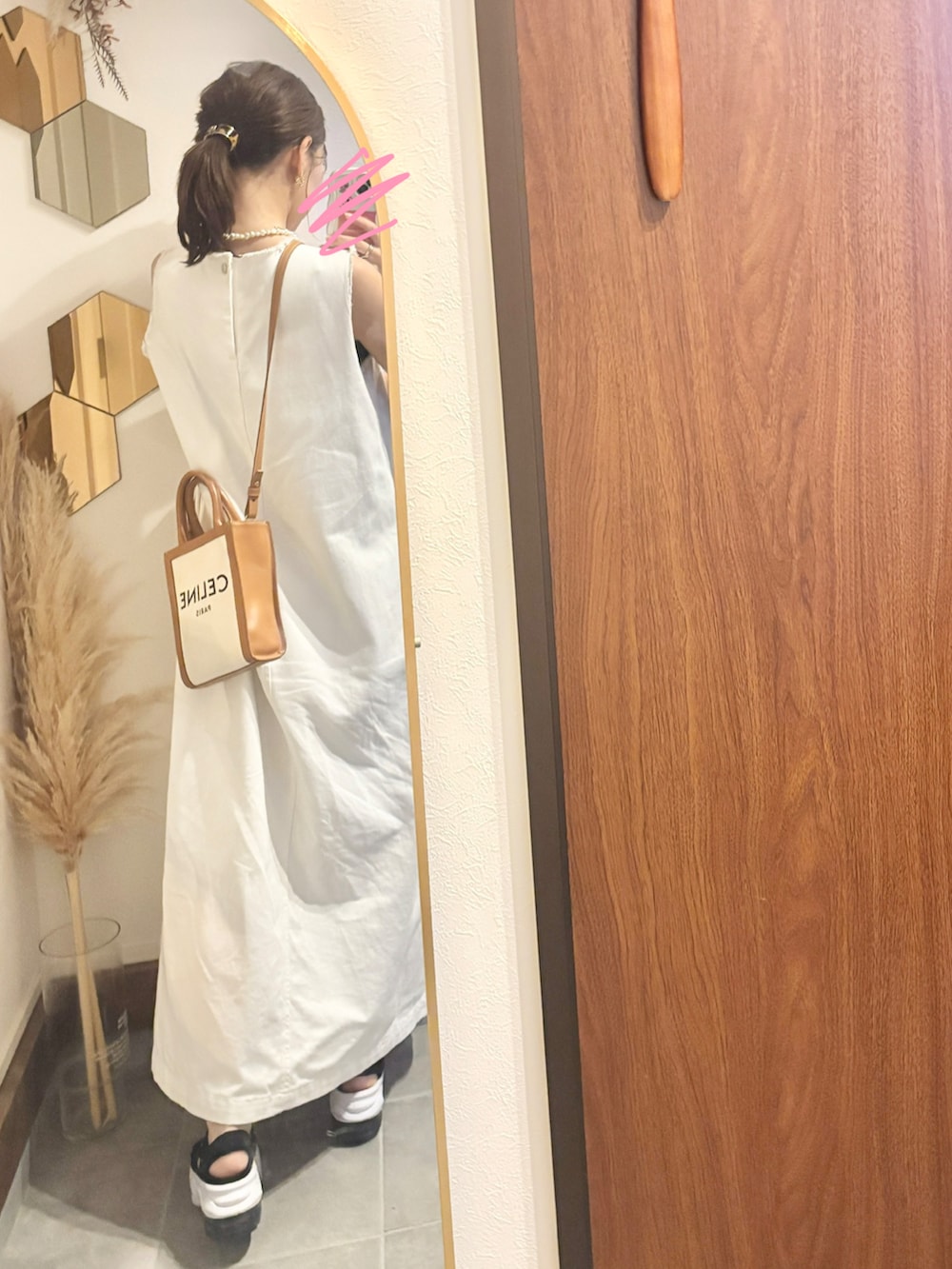 ブラック系のサンダル、ホワイト系のワンピース、ベージュ系のショルダーバッグを着用したレディースの夏コーディネートの2枚目の写真