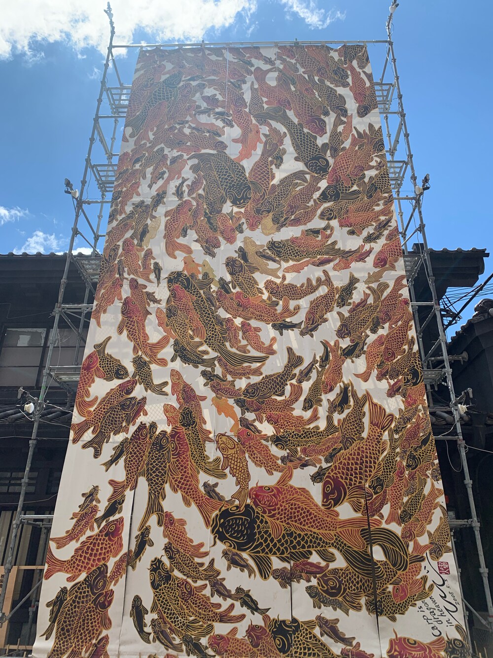 ベージュ系のかごバッグ、ブラック系のワンピース、ブラック系のサンダルを着用したレディースの夏コーディネートの3枚目の写真