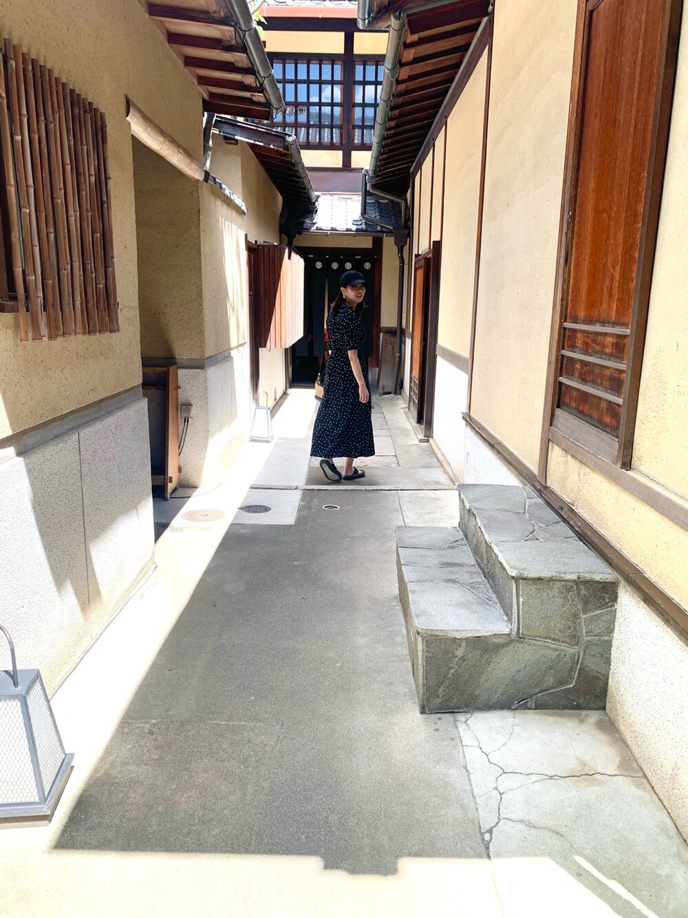 ベージュ系のかごバッグ、ブラック系のワンピース、ブラック系のサンダルを着用したレディースの夏コーディネートの2枚目の写真