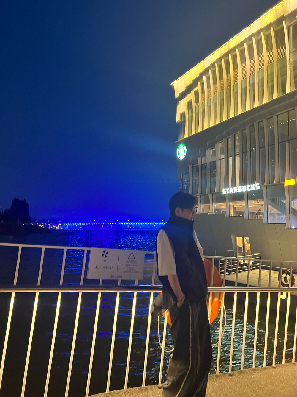 ホワイト系のTシャツ/カットソー、ブラック系のブルゾン、ブラック系のショルダーバッグを着用したメンズの夏コーディネートの3枚目の写真