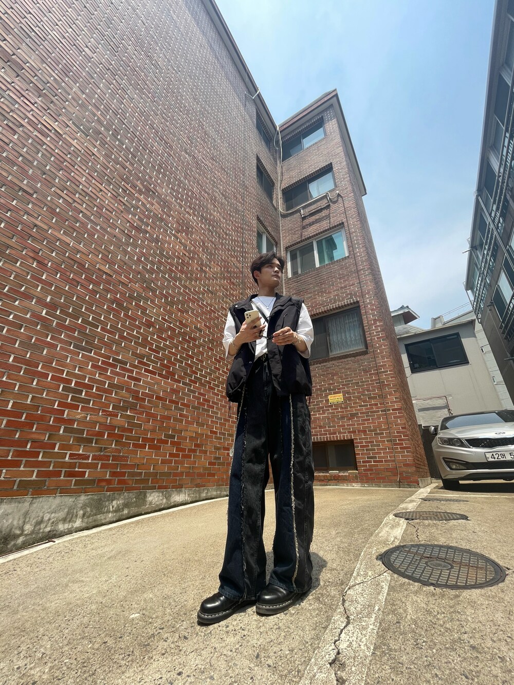 ホワイト系のTシャツ/カットソー、ブラック系のブルゾン、ブラック系のデニムパンツを着用したメンズの夏コーディネートの3枚目の写真