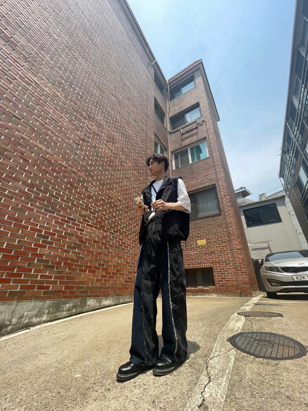 ホワイト系のTシャツ/カットソー、ブラック系のブルゾン、ブラック系のデニムパンツを着用したメンズの夏コーディネートの2枚目の写真