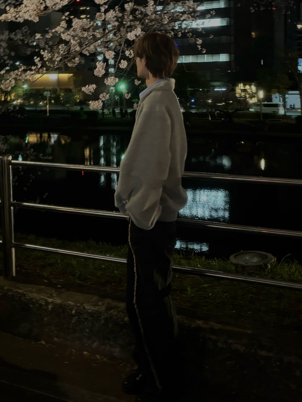 グレー系のニット/セーター、ブラック系のデニムパンツ、ブルー系のローファーを着用したメンズの春コーディネートの2枚目の写真