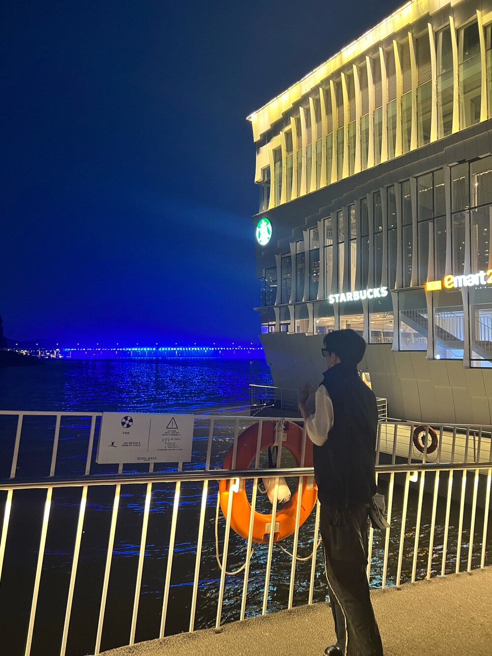 ホワイト系のTシャツ/カットソー、ブラック系のブルゾン、ブラック系のショルダーバッグを着用したメンズの夏コーディネートの2枚目の写真