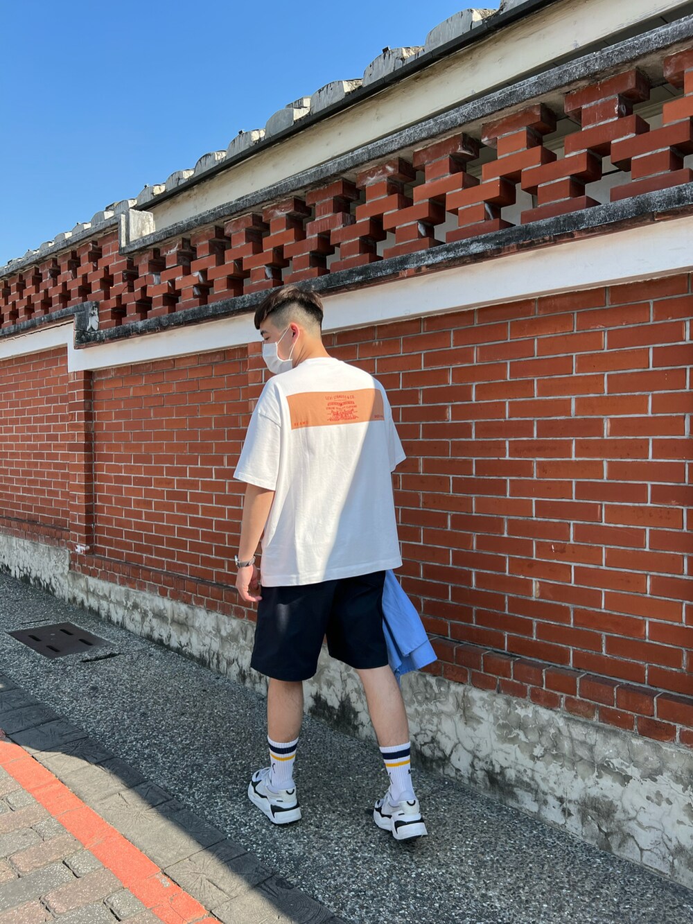 ホワイト系のTシャツ/カットソー、ブラック系のカーゴパンツ、ホワイト系のスニーカーを着用したメンズの春コーディネートの2枚目の写真