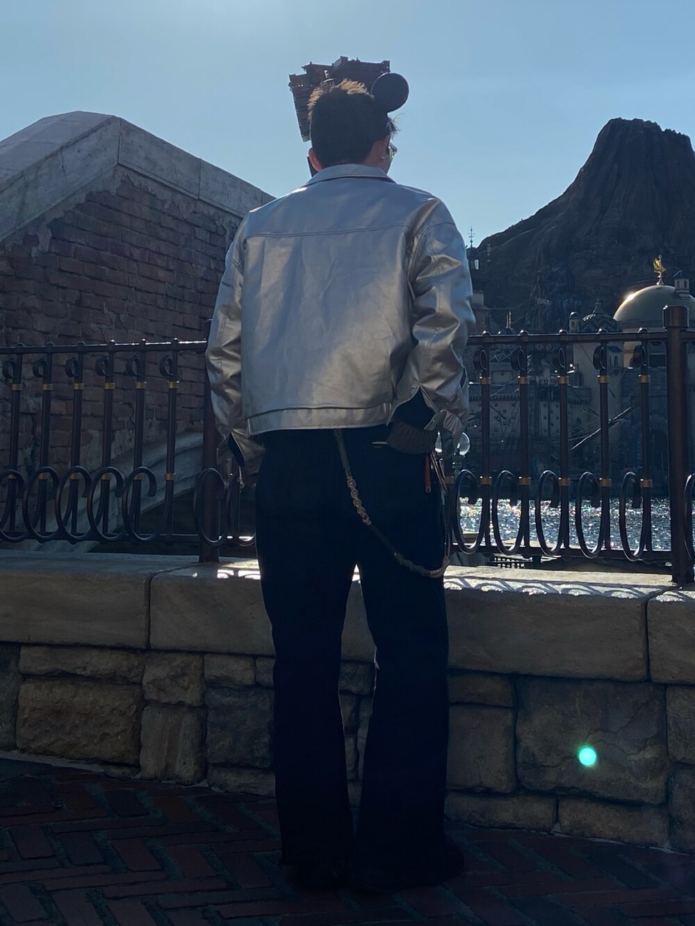 シルバー系のブルゾン、ブラック系のデニムパンツを着用したメンズの春コーディネートの3枚目の写真