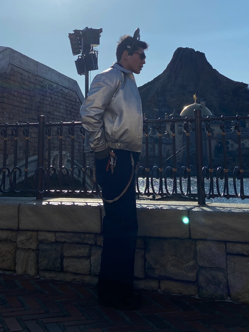 シルバー系のブルゾン、ブラック系のデニムパンツを着用したメンズの春コーディネートの2枚目の写真