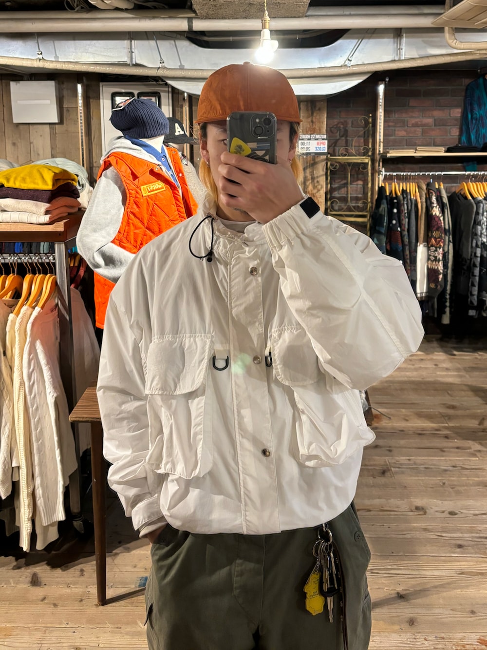 ブラック系のスニーカー、ホワイト系のナイロンジャケットを着用したメンズの秋コーディネートの2枚目の写真